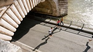 View of joggers running under the Pont de Bir-Hakeim in Paris, France during the day.