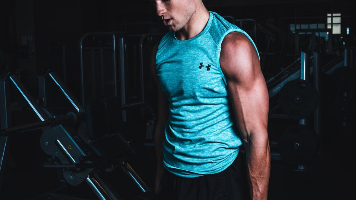 Man exercising indoors, lifting dumbbells for strength training in a Towson gym.